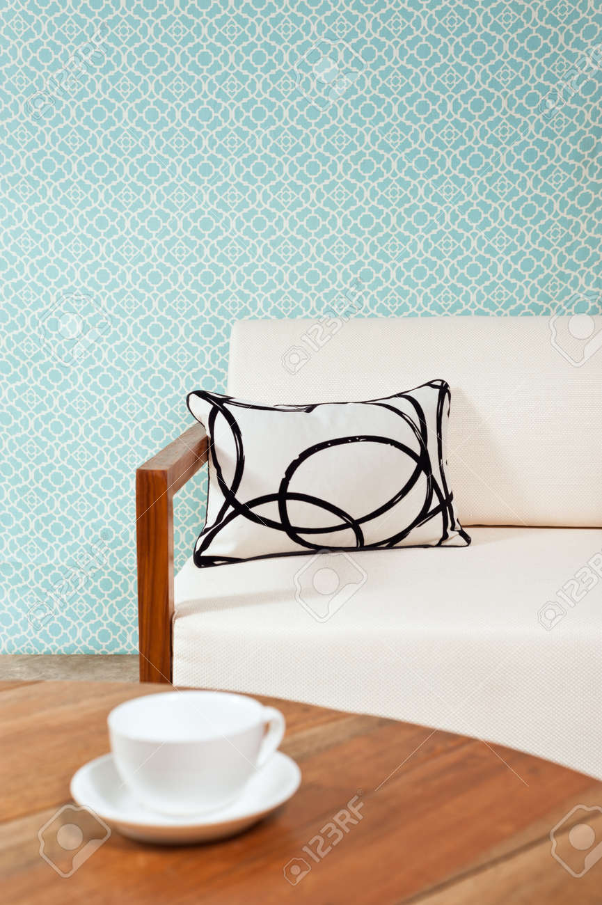 Heldere witte meubels in een woonkamer met turquoise blauw behang ...