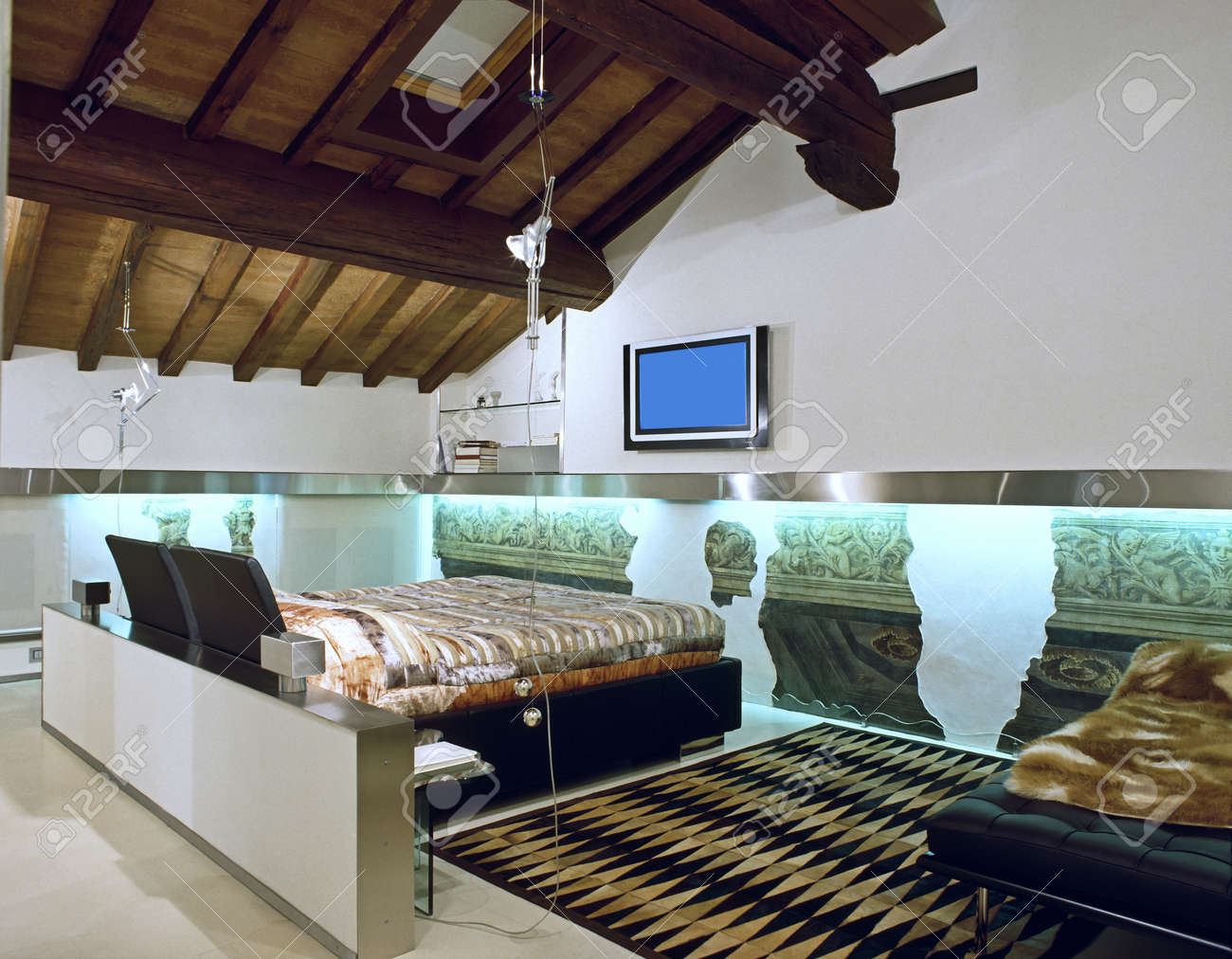 Moderne slaapkamer op de zolder ruimte met houten plafond en ...