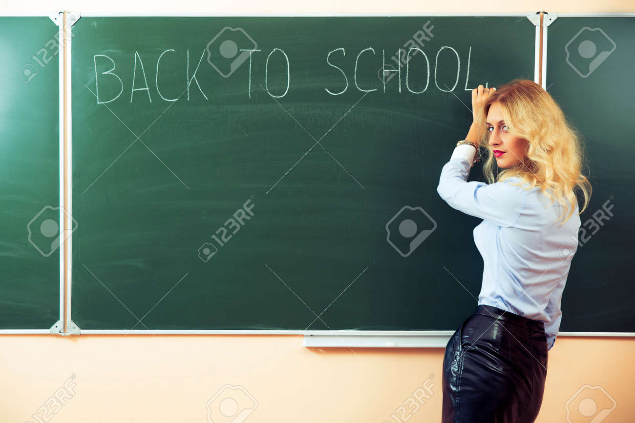 29294958-Beautiful-young-sexy-teacher-standing-near-the-blackboard-Stock-Photo.jpg