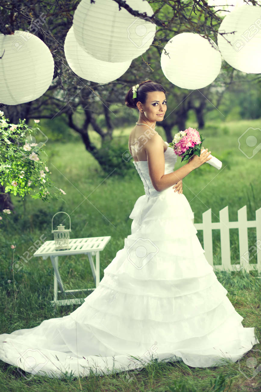 Bella sposa in posa con decorazioni bianco sotto lanterne di carta ... Decorazione Romantico Giardino