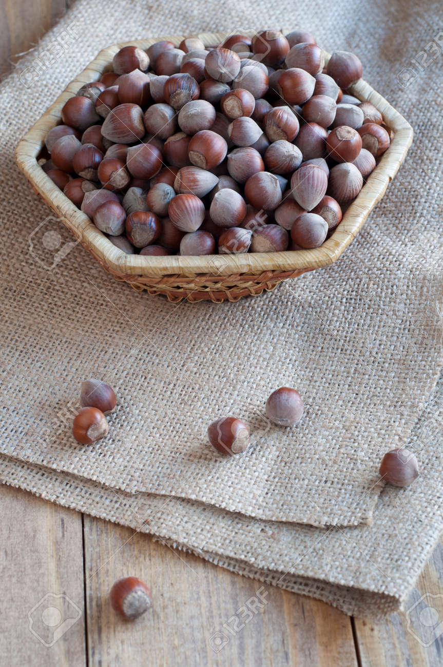 Nocciole in zolla di vimini su un tavolo vecchio coperte di tela ... Tavolo vecchio