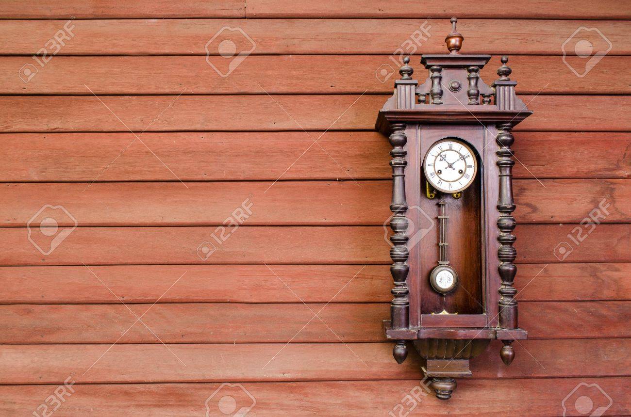 Antico orologio a pendolo in legno appeso alla parete di legno ...