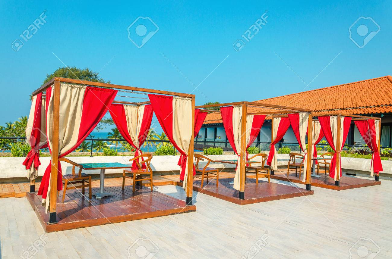 Pergolati con tavoli e sedie, tende rosse in ristorante di hotel ...