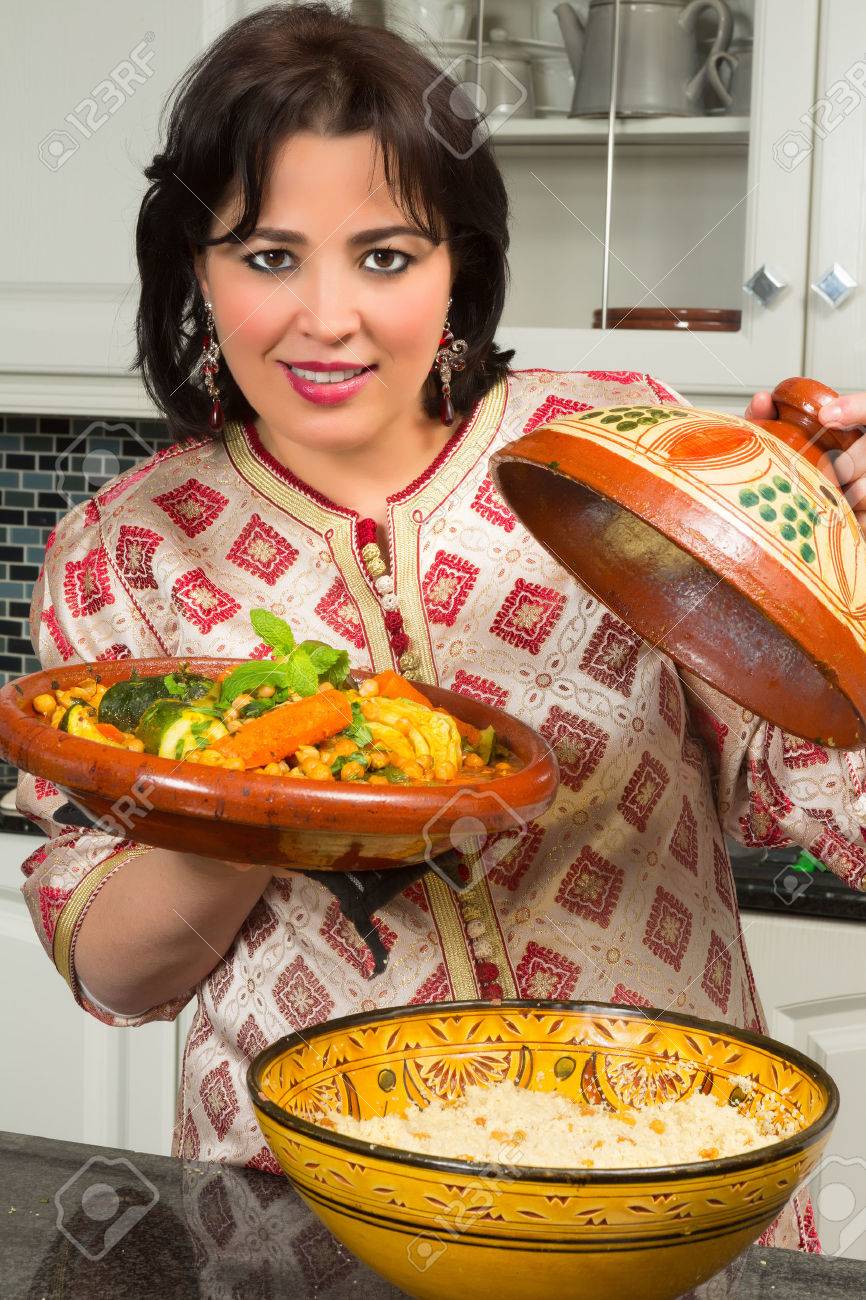 Belle femme marocaine immigrée en europe présentant son plat à ...