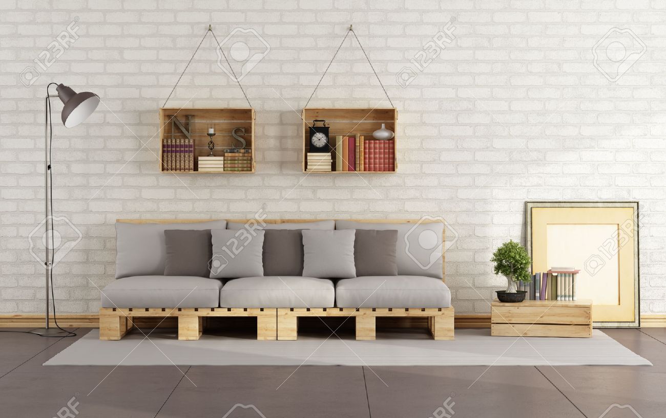 Woonkamer met pallet sofa en een houten kist met boeken op de muur ...