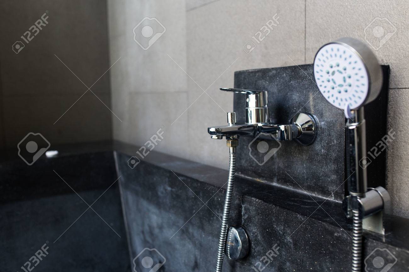 Jacuzzi moderne avec robinet et douche à main dans une salle de ...
