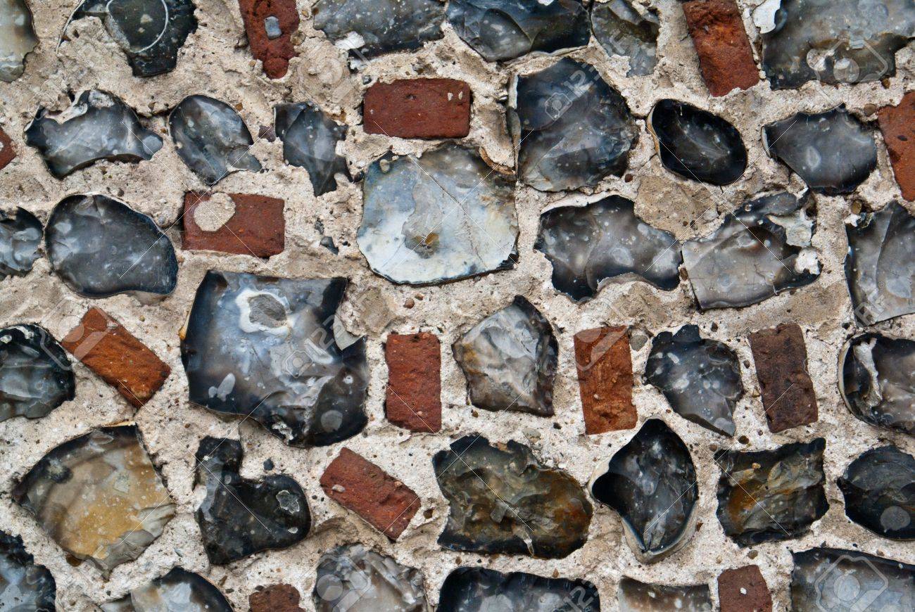 Un muro di pietra e mattoni di selce esterni foto royalty free ...