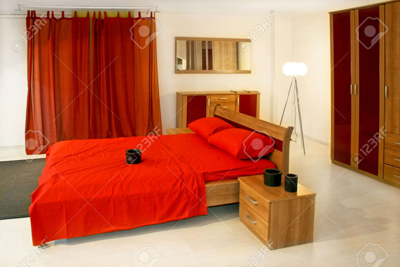 Chambre à coucher avec des meubles en bois rouge et la literie ...