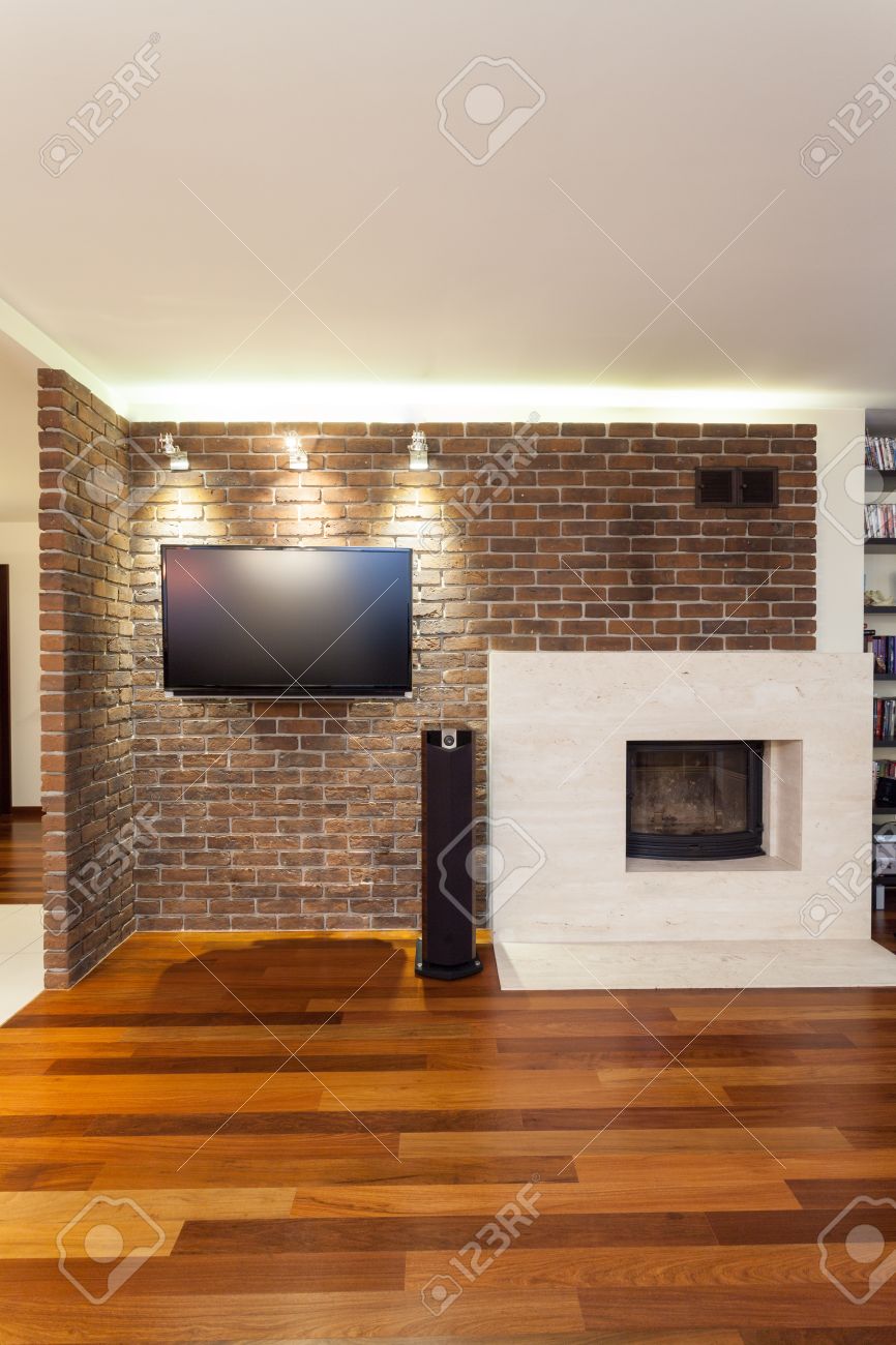Ruim appartement bakstenen muur met open haard en tv royalty ...