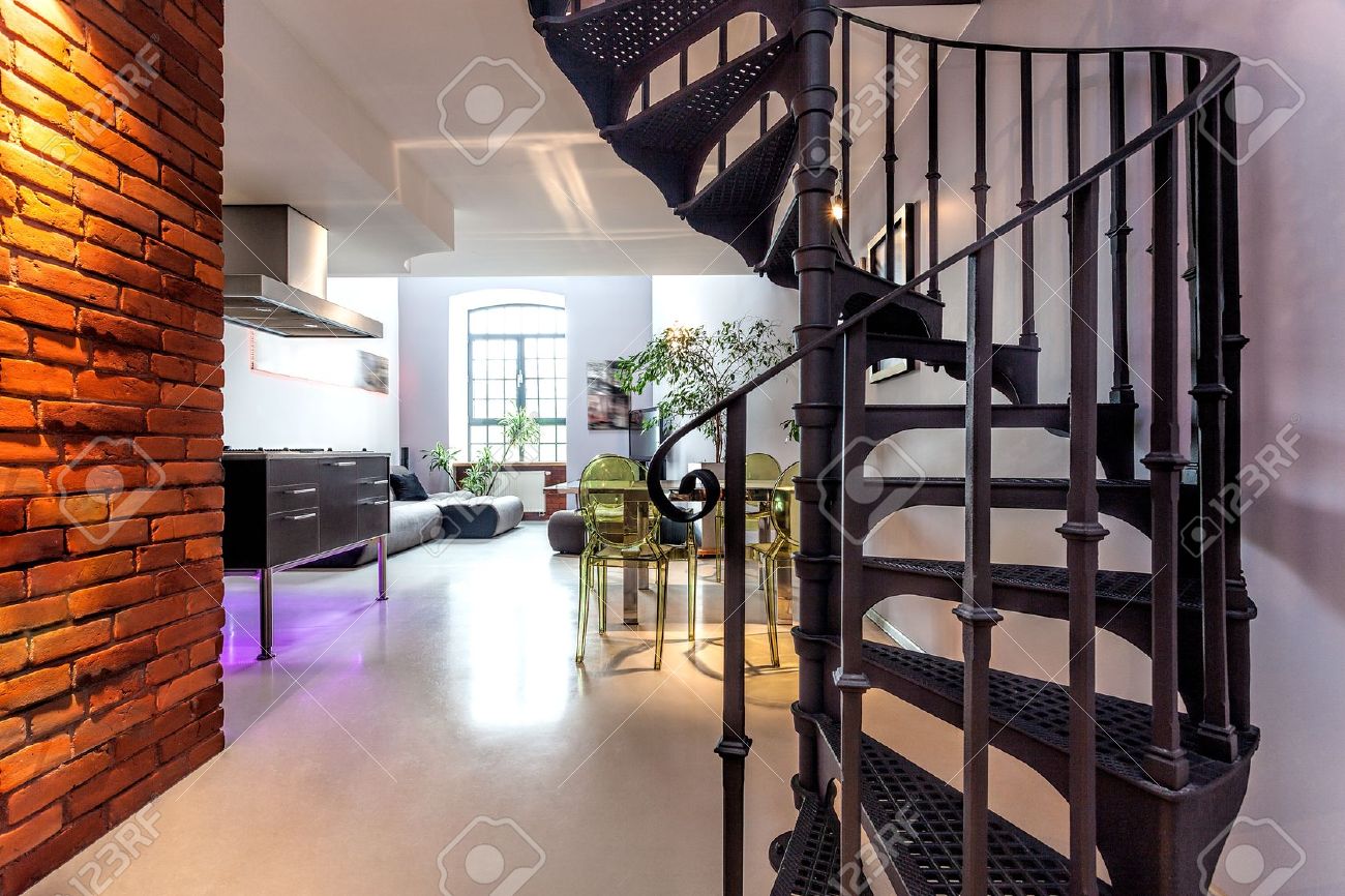 Spiraalvormige trap en woonkamer in een moderne loft royalty vrije ...