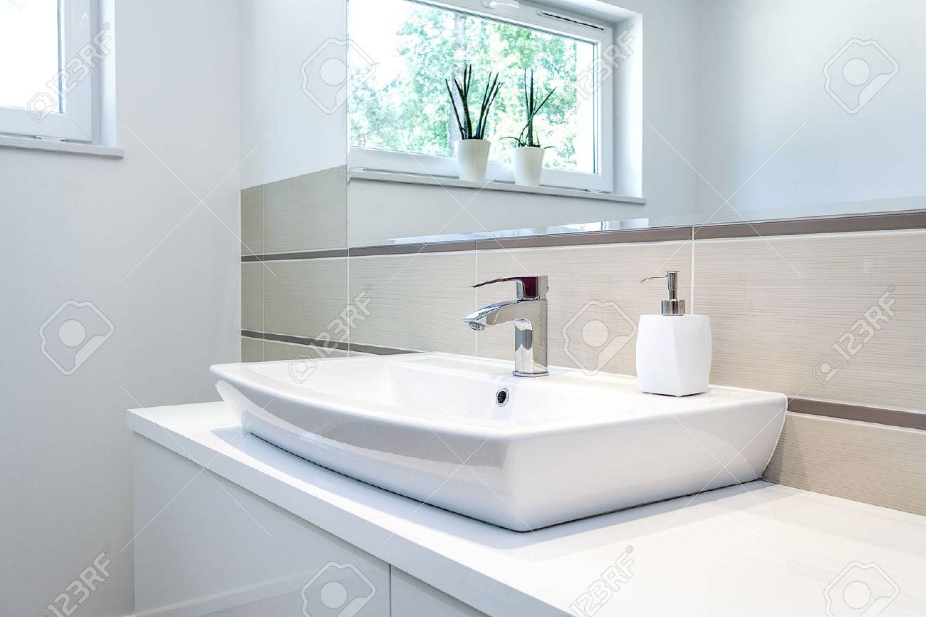Espace lumineux un robinet d'argent dans une salle de bain blanc ...