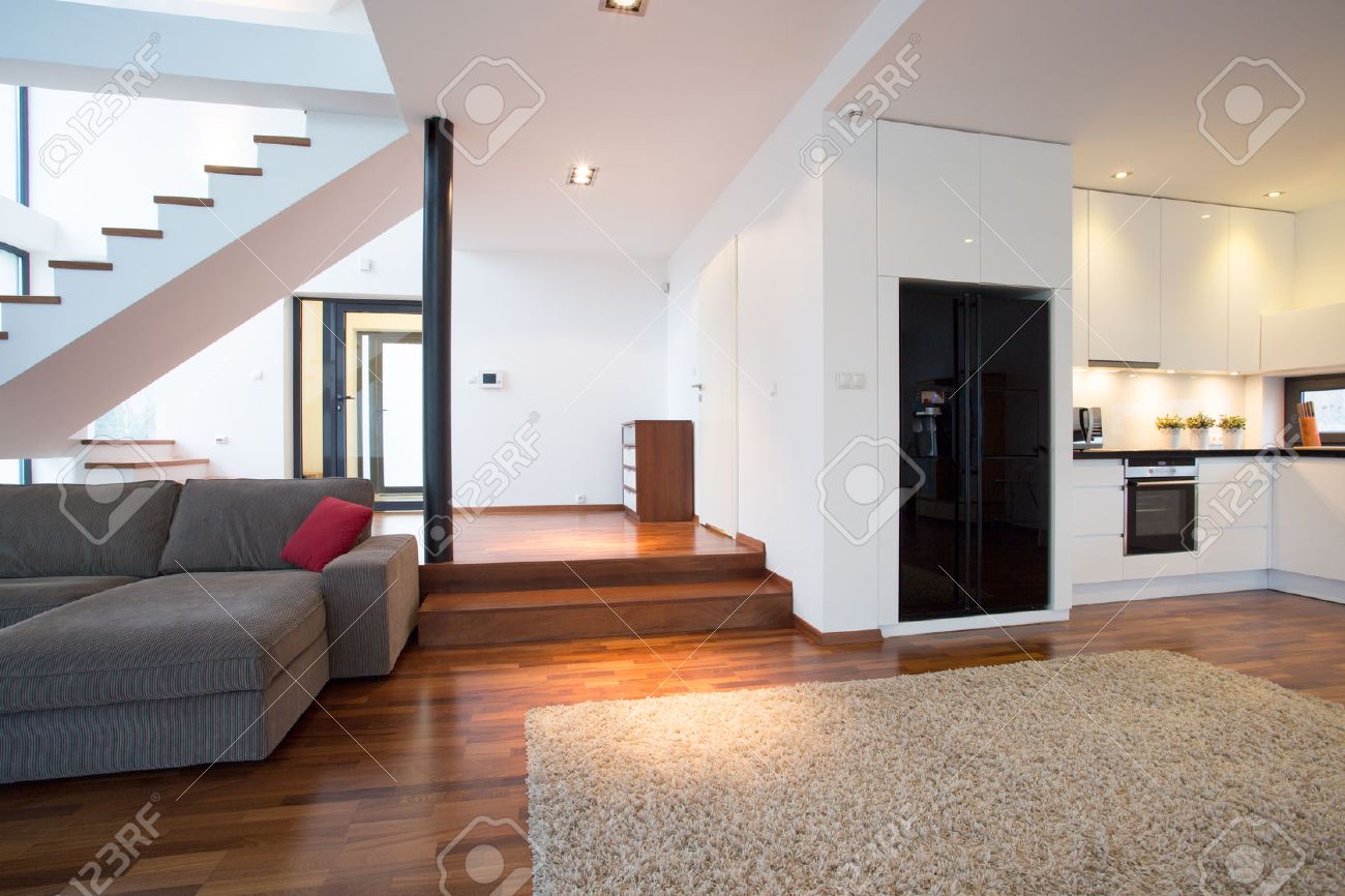 Salon spacieux et moderne avec des escaliers menant au premier ...