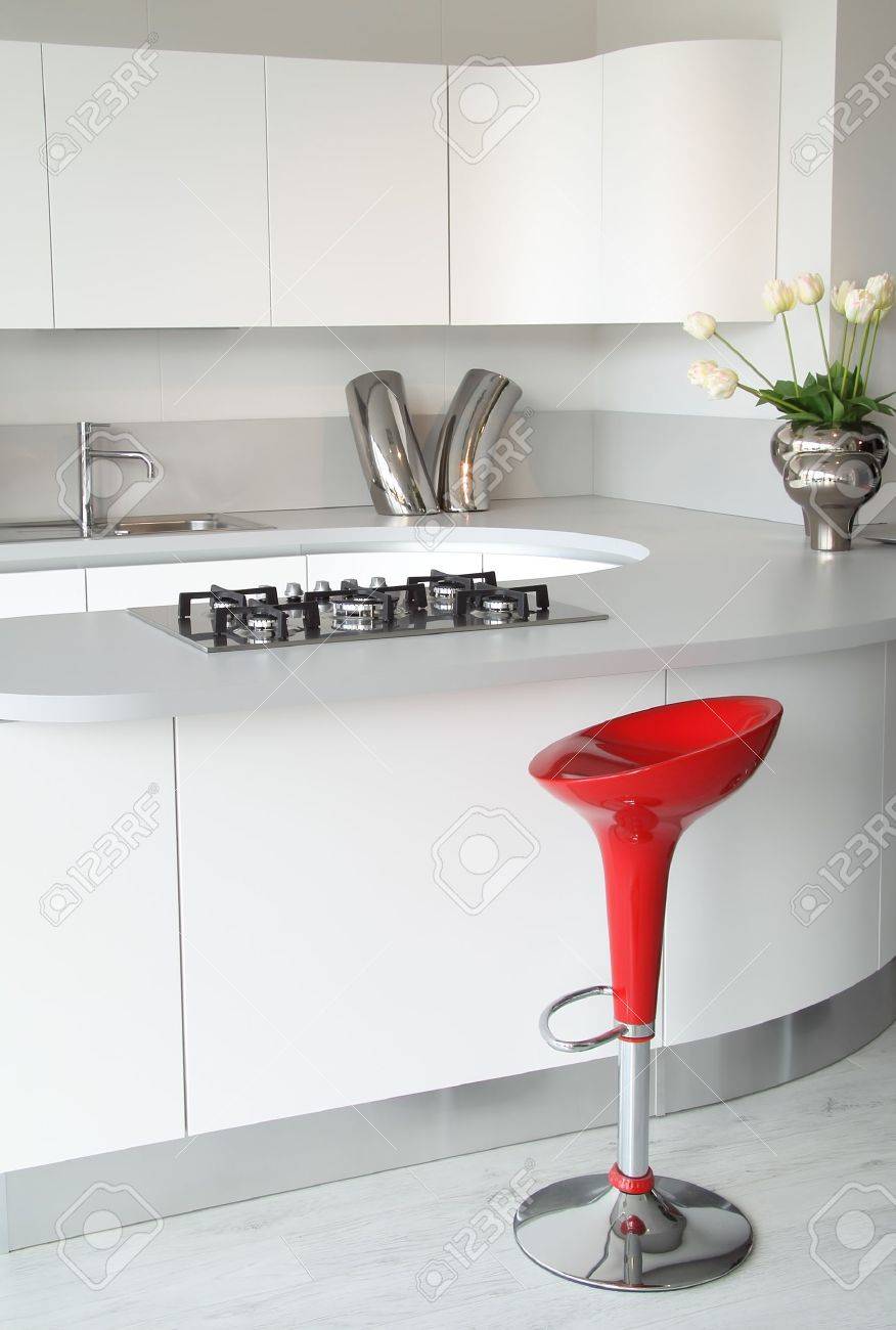 Moderne witte keuken met stijlvolle en elegante rode kruk. royalty ...