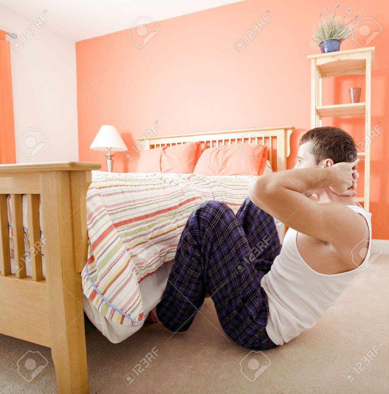 Uomo facendo sit up nella sua camera da letto, con i suoi piedi ... Camera letto uomo