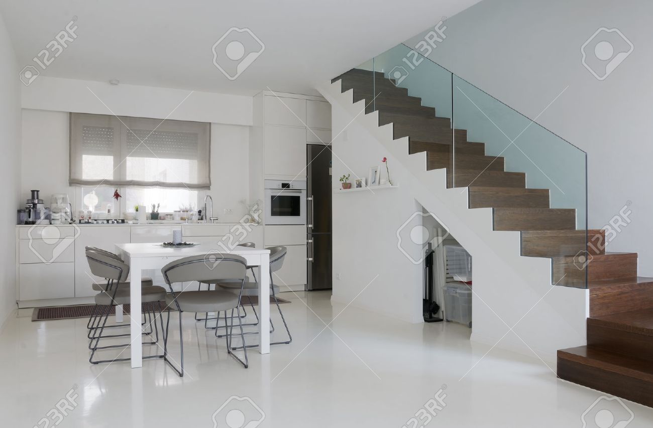 Witte keuken en eetkamer met witte epoxy vloer en houten trap ...