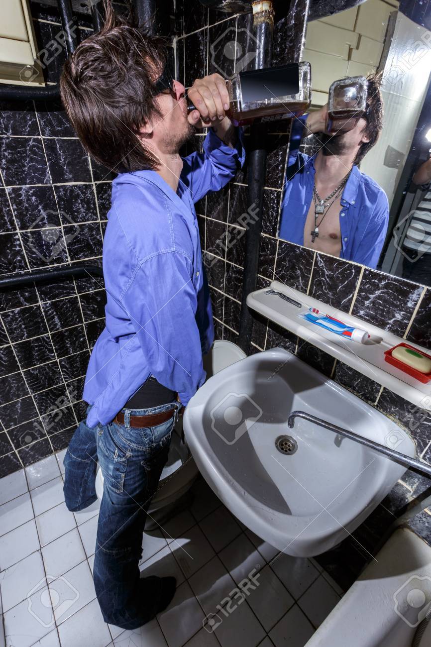 Betrunkener mann in einem wc stehend mit einer flasche whisky bildfarbe lizenzfreie bilder 41354039