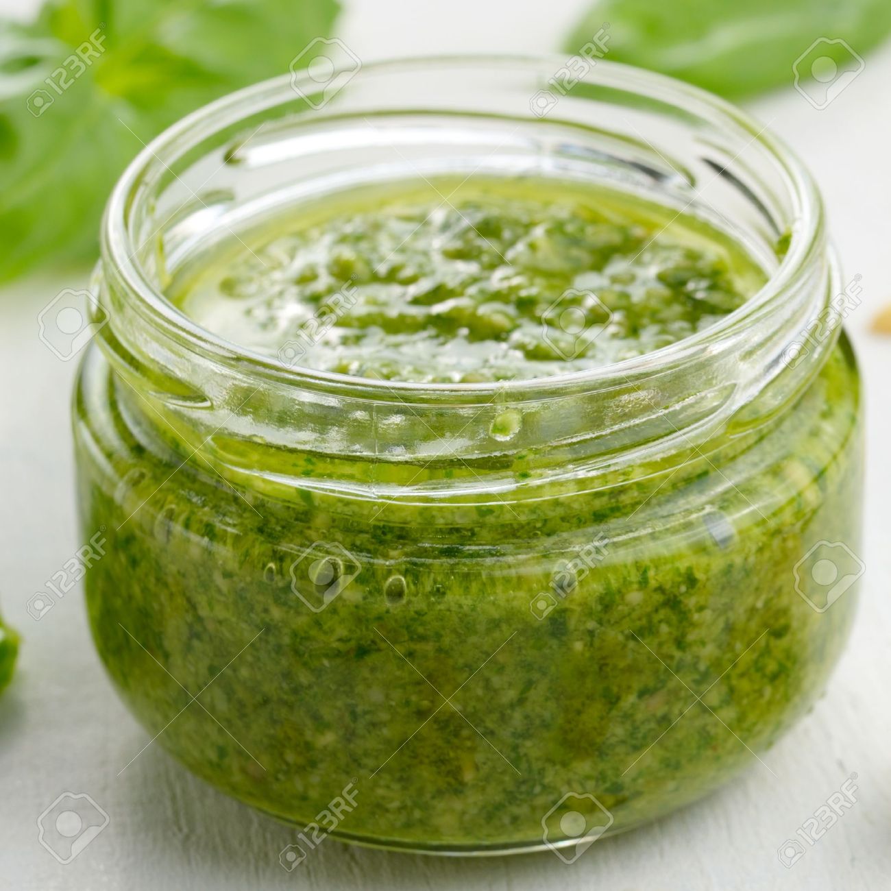 Glasburk av pesto sås på vitt köksbord närbild royalty fria ...
