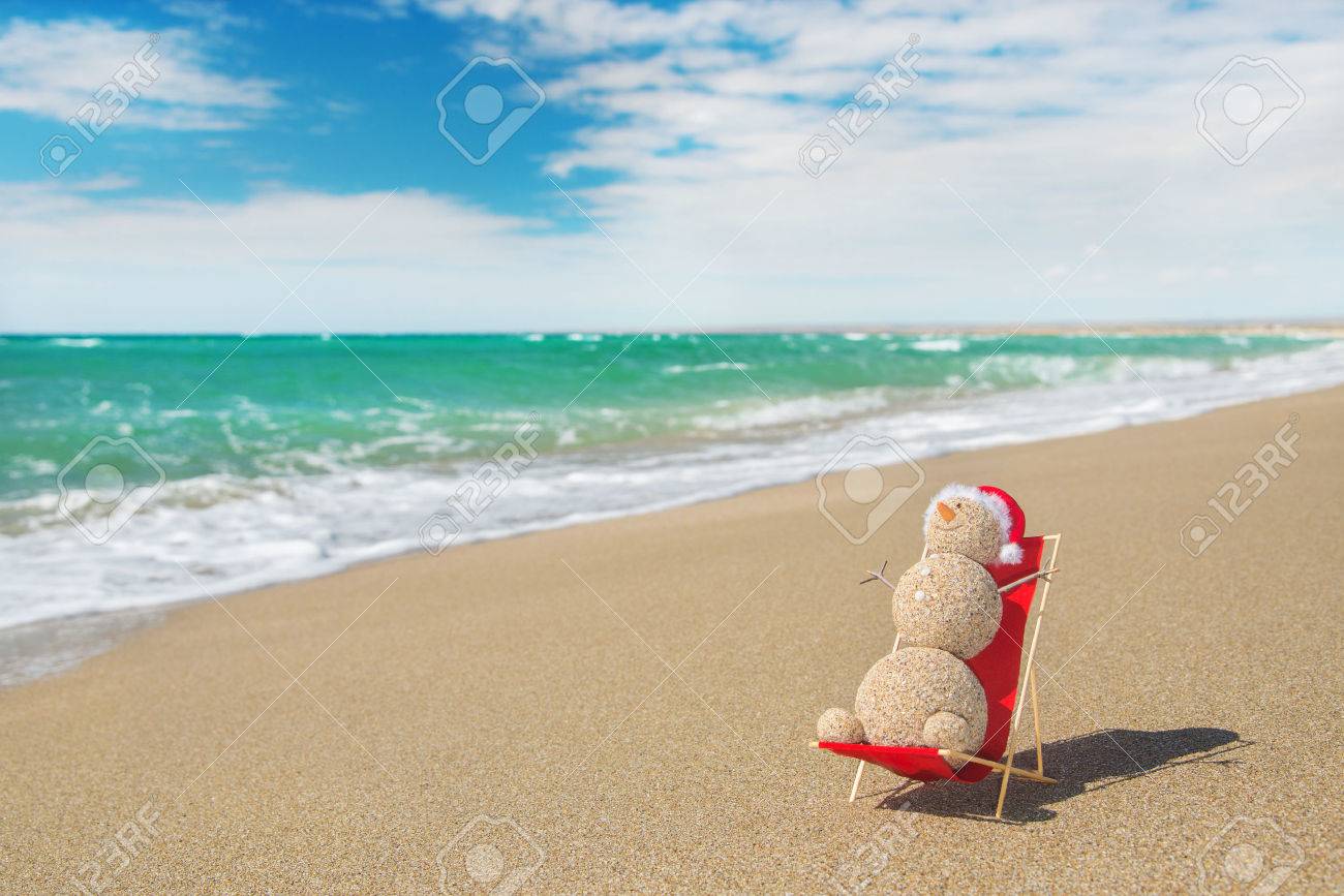 Sandy sneeuwman in rode kerstmuts zonnebaden op het strand lounge ...