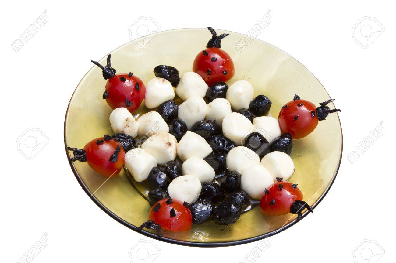 Tasty decorated plate with black olives, ladybug tomatoes ...