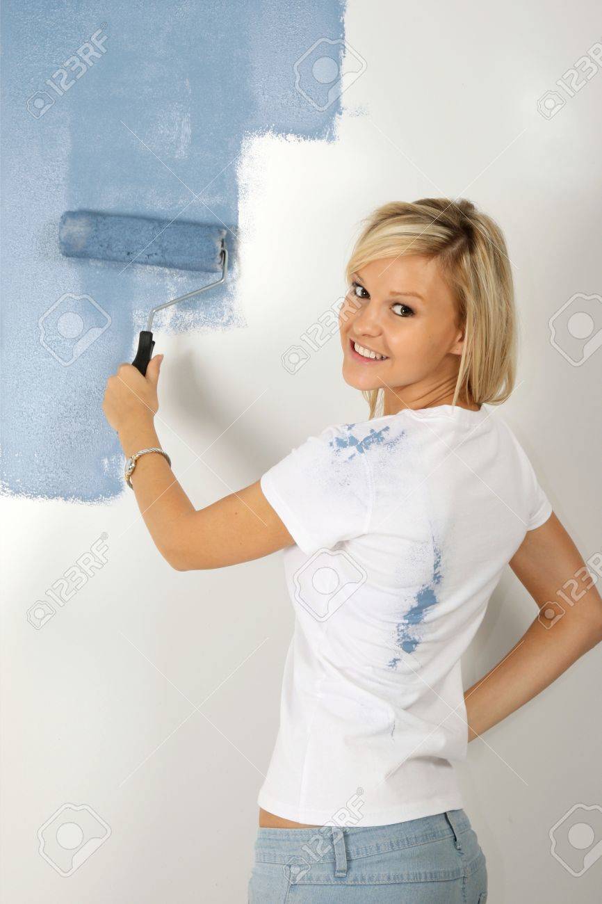 Mooie blonde dame schilderen een slaapkamer kamer poeder blauwe ...