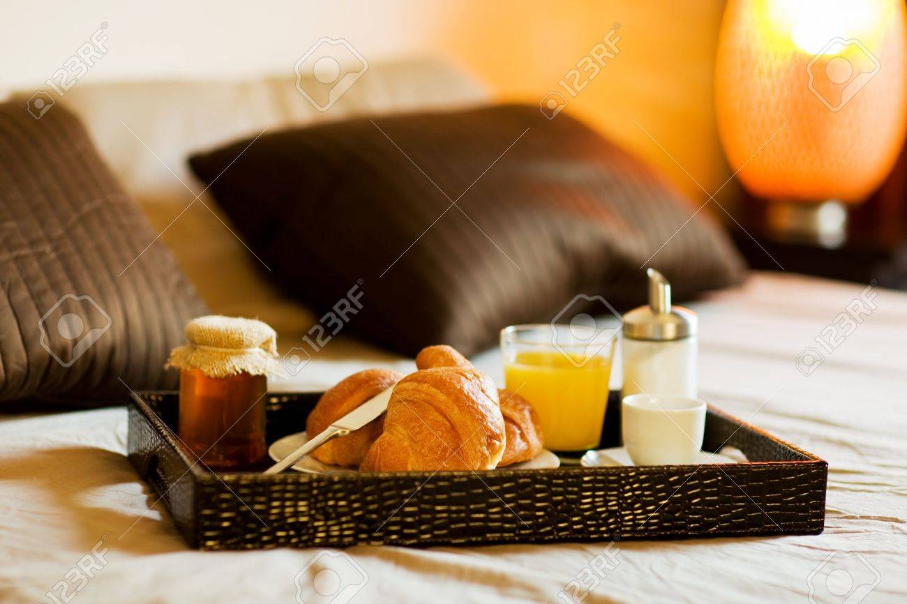 Foto van dienblad met ontbijt eten op het bed in een slaapkamer ...