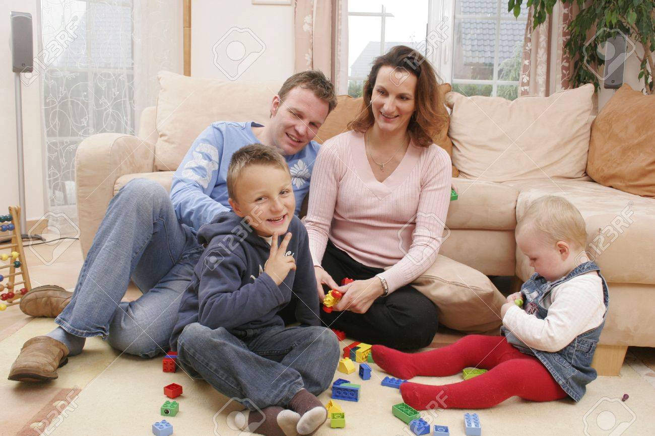 Living Room Family Living Room young family is playing on the living room rug stock photo rug