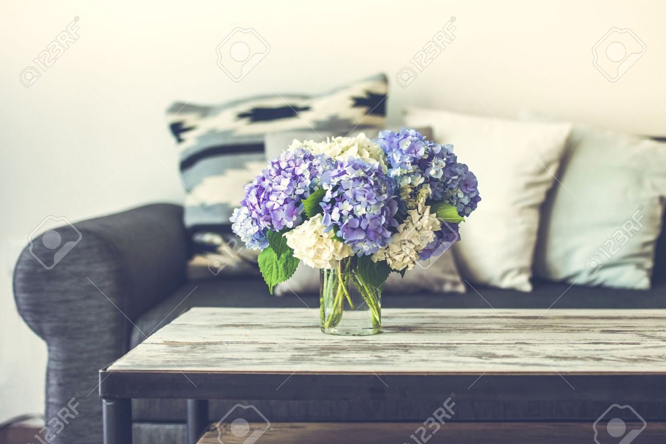 Boeket hortensia bloemen op moderne houten salontafel en gezellige ... Ontwerp salontafel woonkamer