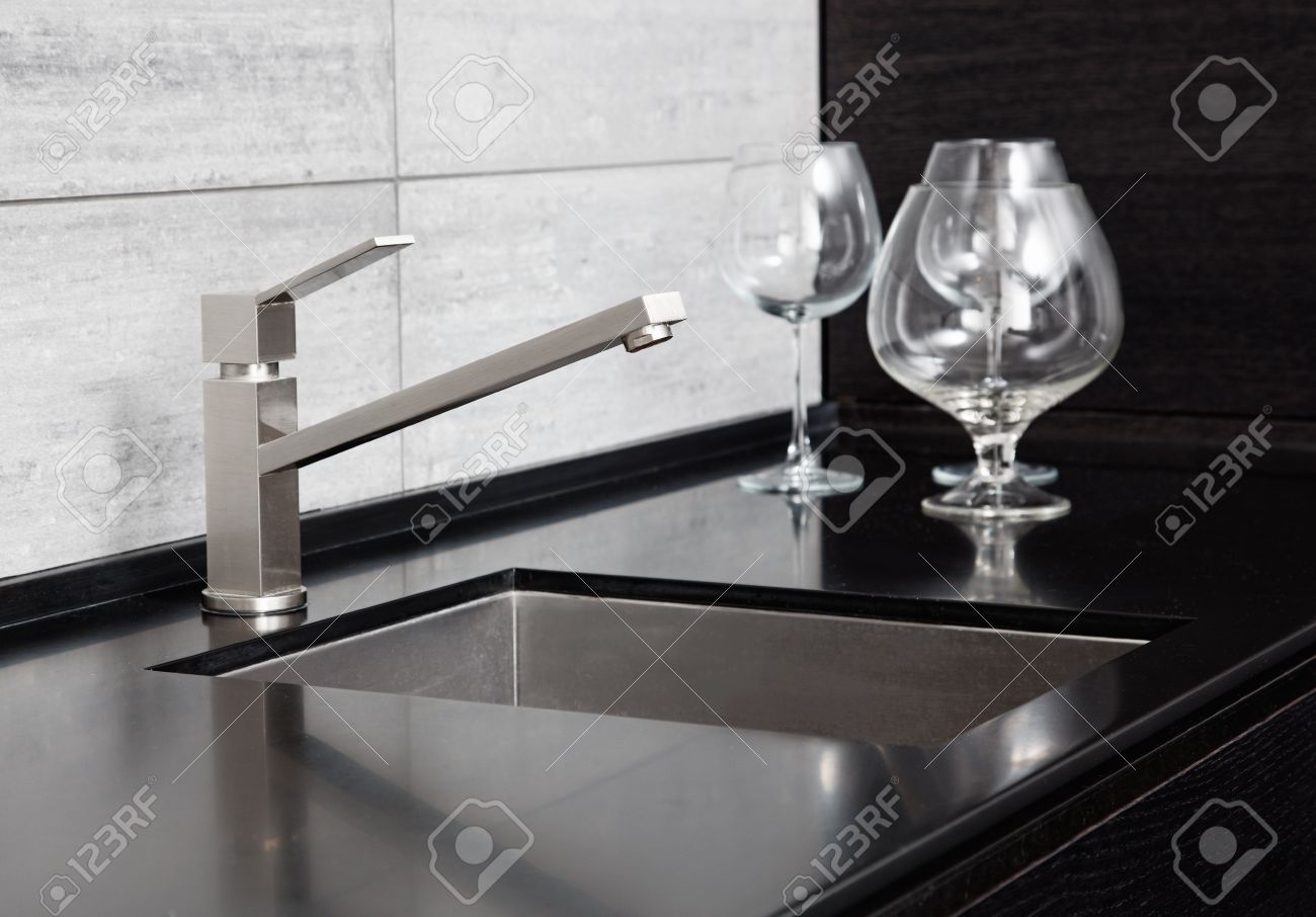 Moderne keuken gootsteen met metalen kraan en zwart marmer royalty ...