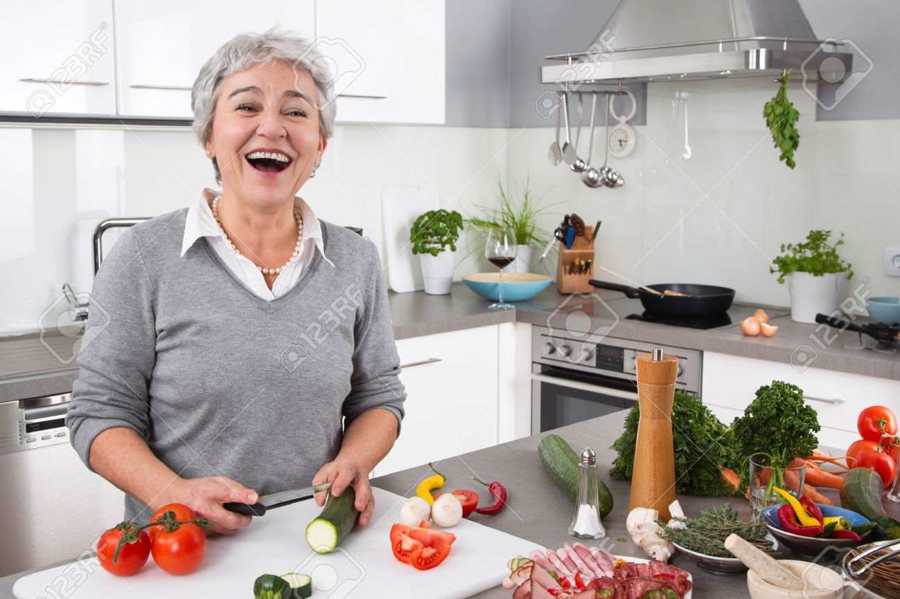 Senior of oudere vrouw met grijs haar koken in de keuken ... Grijze keuken fotos