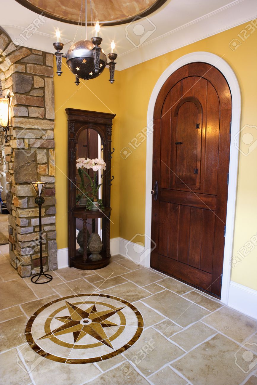 Arched front door and ceramic tile entryway of luxury home with ...