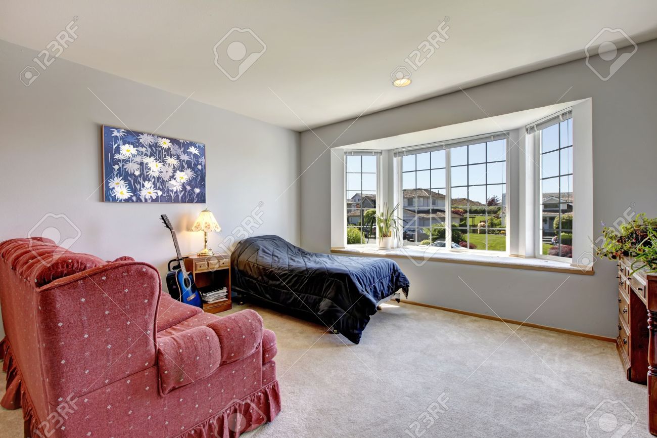 Chambre avec grande fenêtre et petit lit avec un fauteuil et de l ...