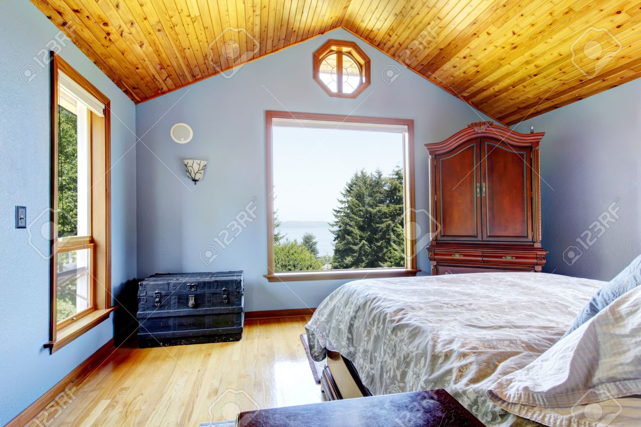 Blauwe slaapkamer met houten plafond en bed, grote ramen interieur ...
