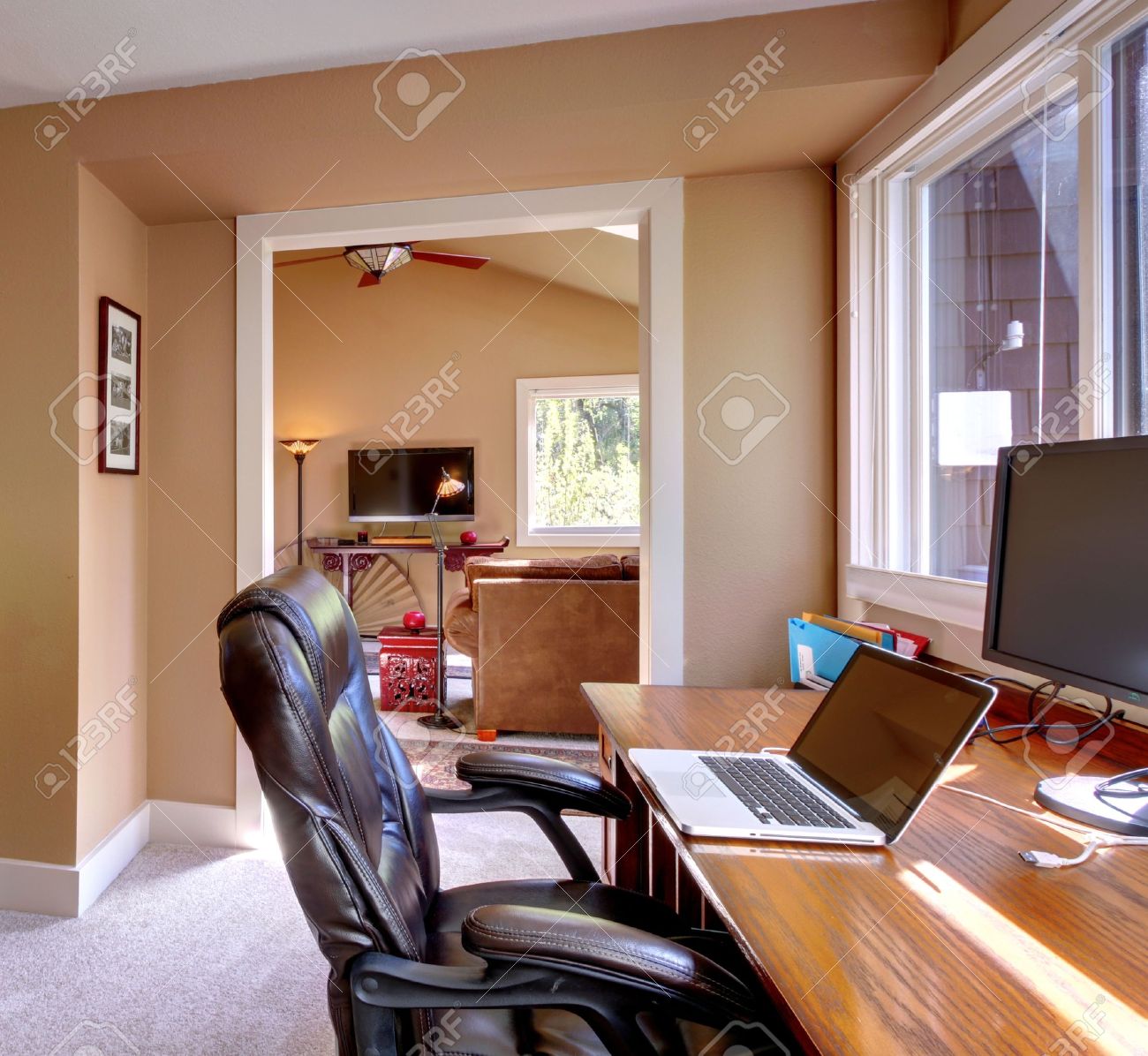 Home office en computer en stoel met bruine muren en een tv in de ...