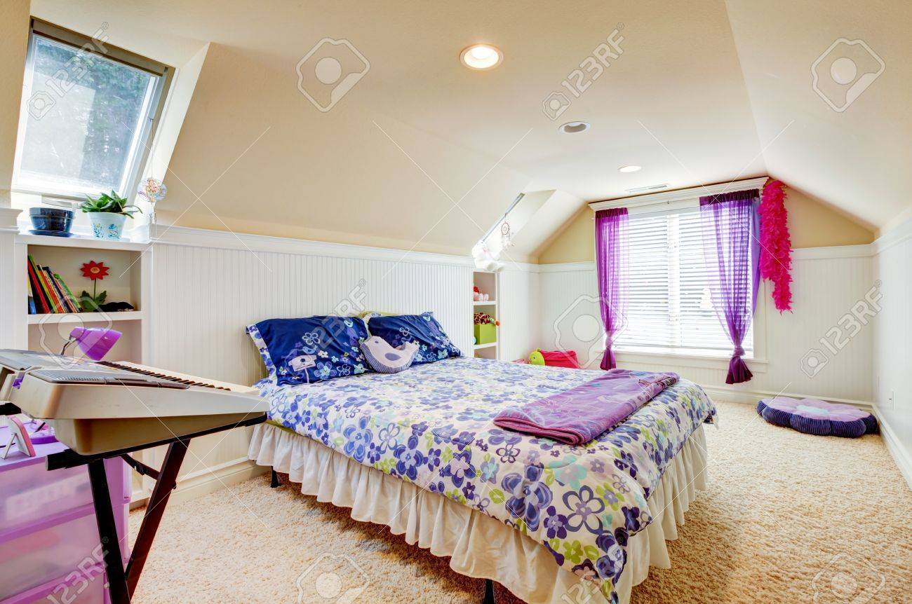 Meisje slaapkamer met zolder gewelfd plafond en beige tapijt met ...