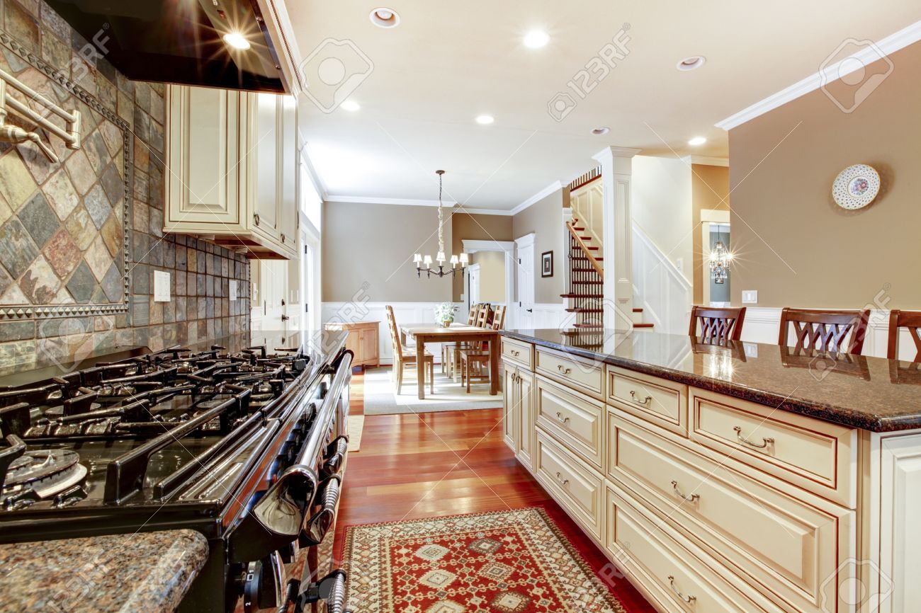 Witte luxe keuken met stenen, groot fornuis en kersen hardhout ...