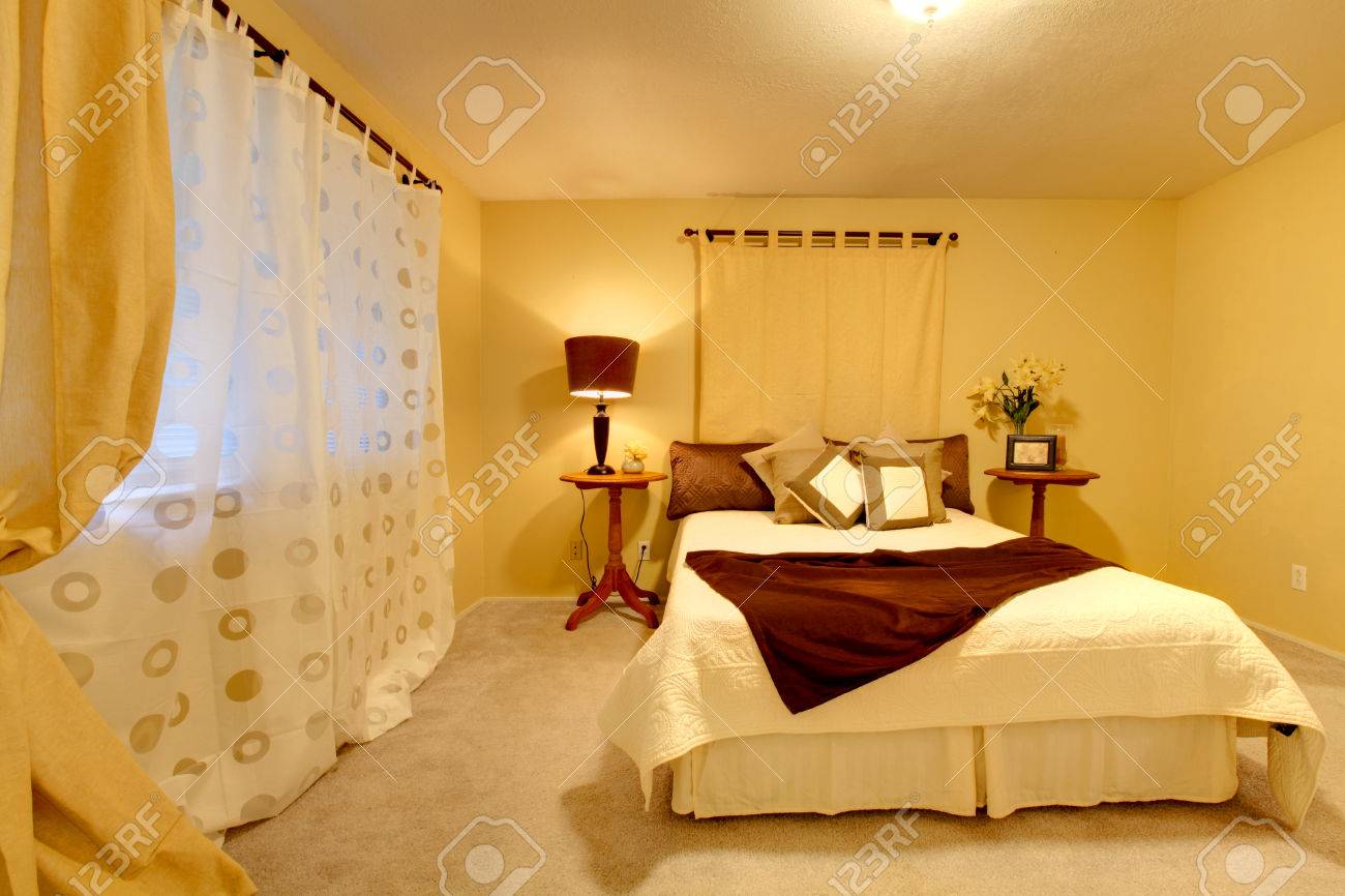 Elegante slaapkamer met licht gele muren en gematched slaapkamer ...