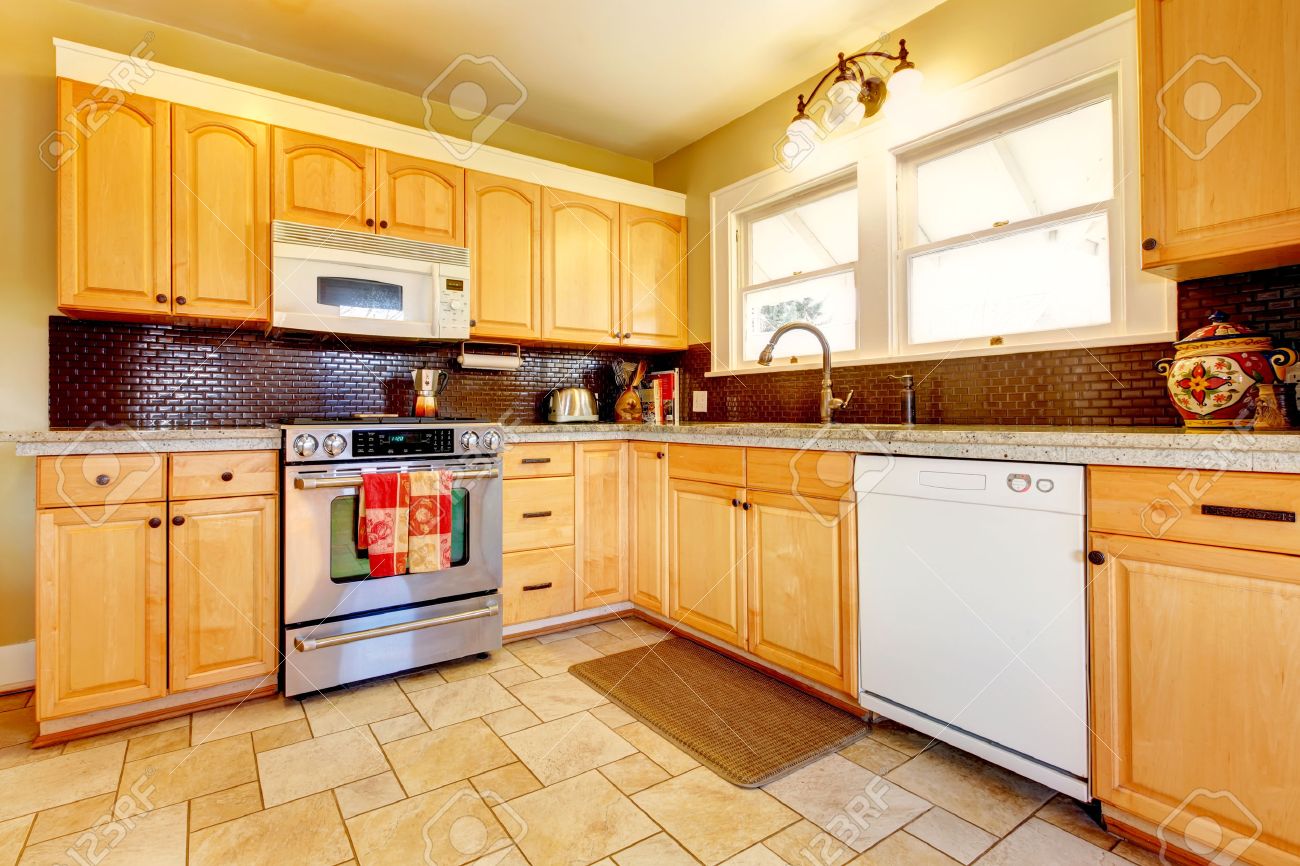 Yellow kitchen with wood cabinets and dark brown backsplash design ...
