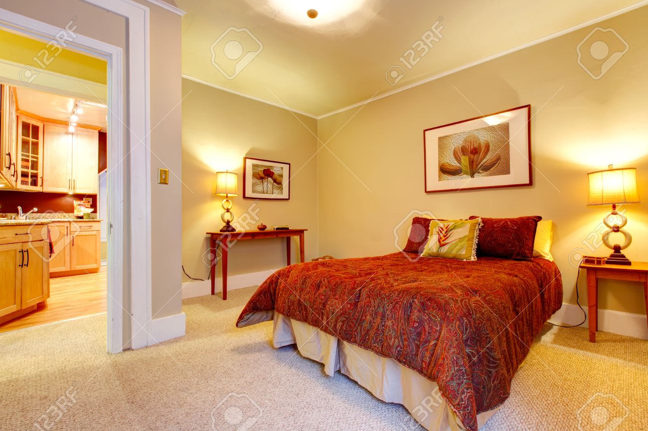 Lichte slaapkamer met beige tapijt vloer en gele muren. rode ...