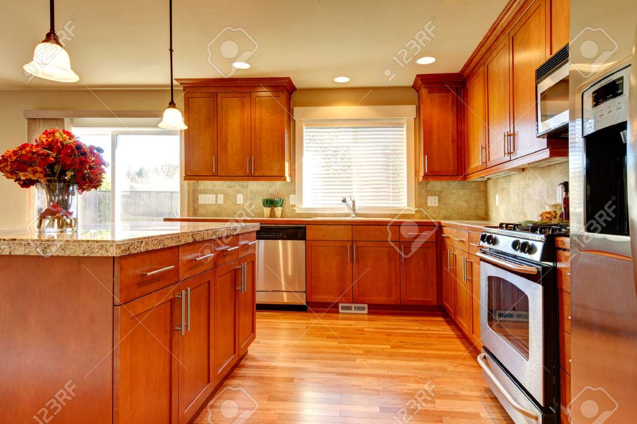 Helle küche mit holzboden, holz schränke, moderne stahlgeräte und ...