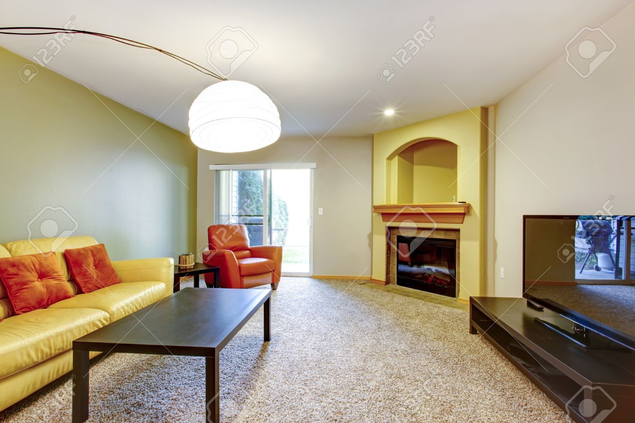 Helles wohnzimmer mit gelben und orangefarbenen couch und sessel ...