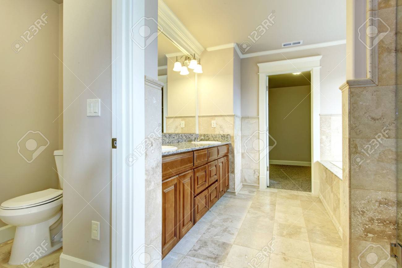 Salle de bain blanc et beige avec armoires en bois, carrelage ...