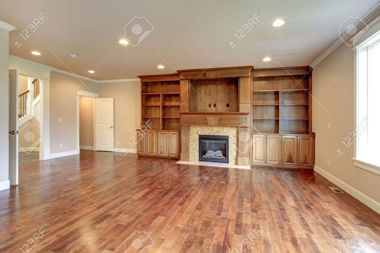 Lichte woonkamer met hardhouten vloer, beige muur, houten berging ...