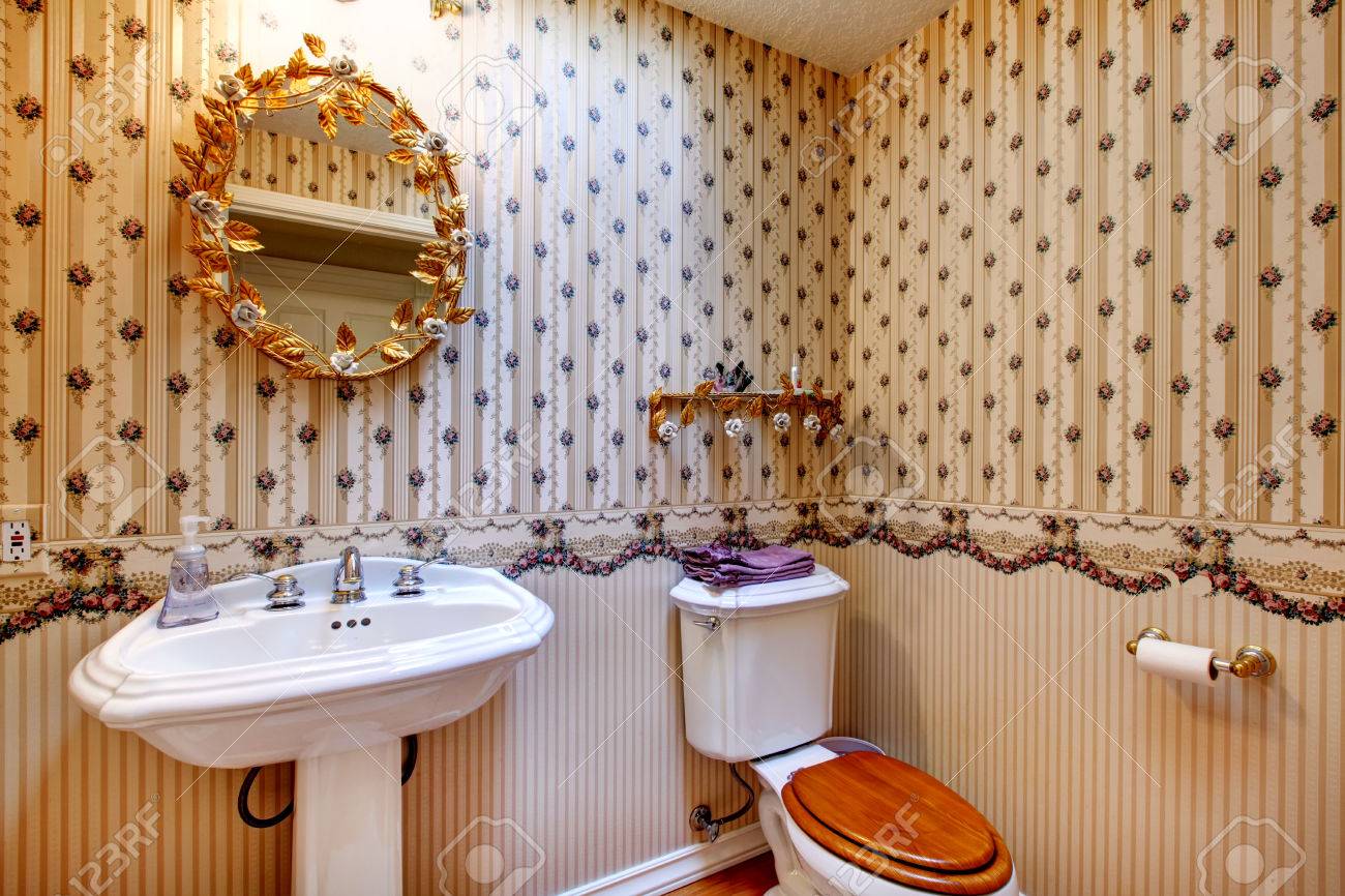 Ouderwetse stijl badkamer met behang, versierd gouden spiegel en ...