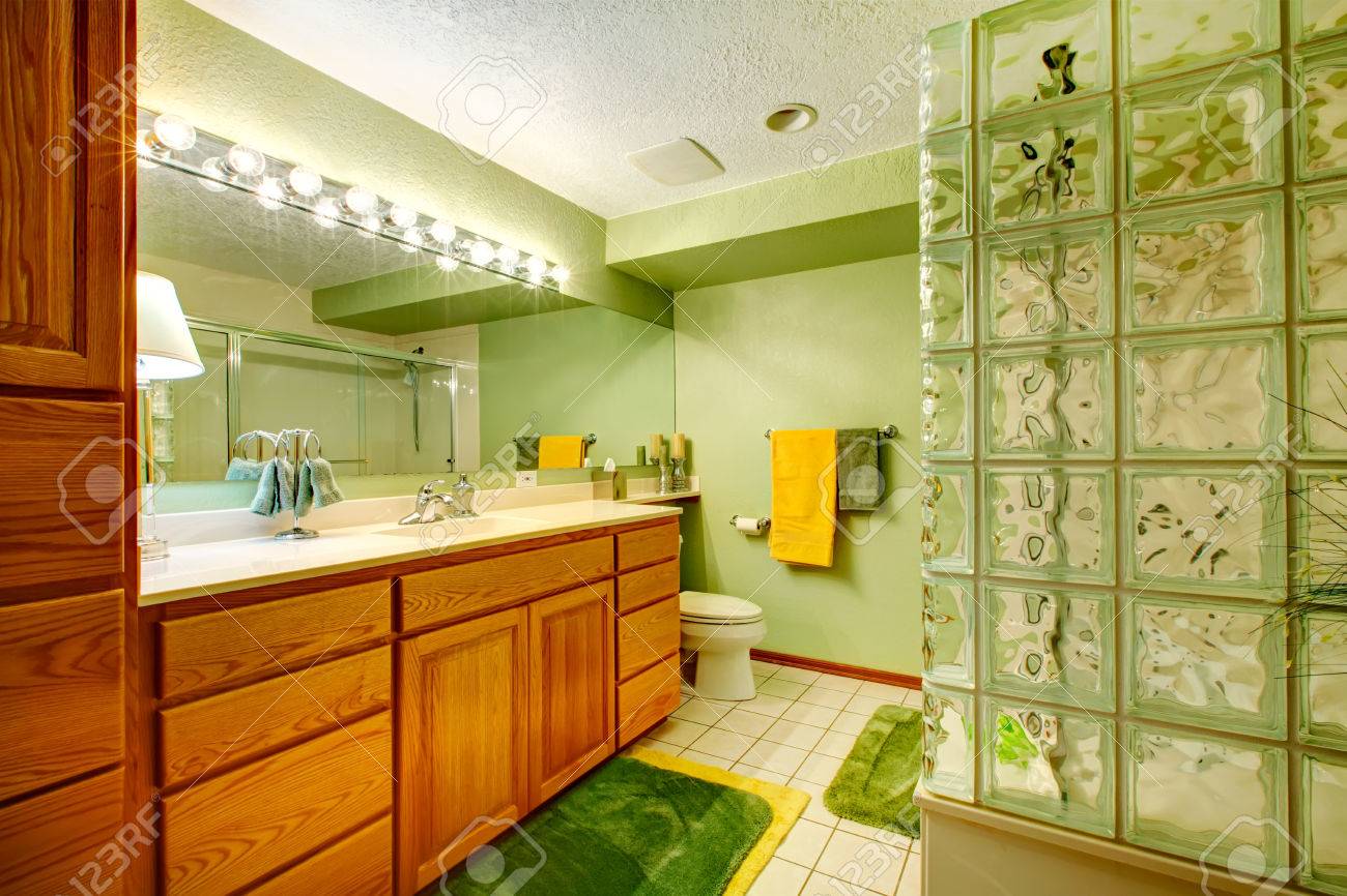 Salle de bains avec des armoires vert brun, carrelage, tapis vert ...