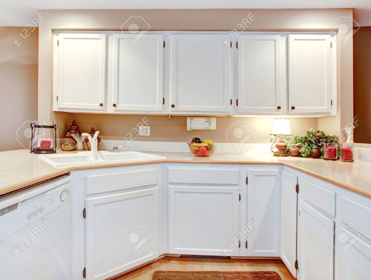 Lichte keuken met witte houten kasten en beige aanrechtbladen ...