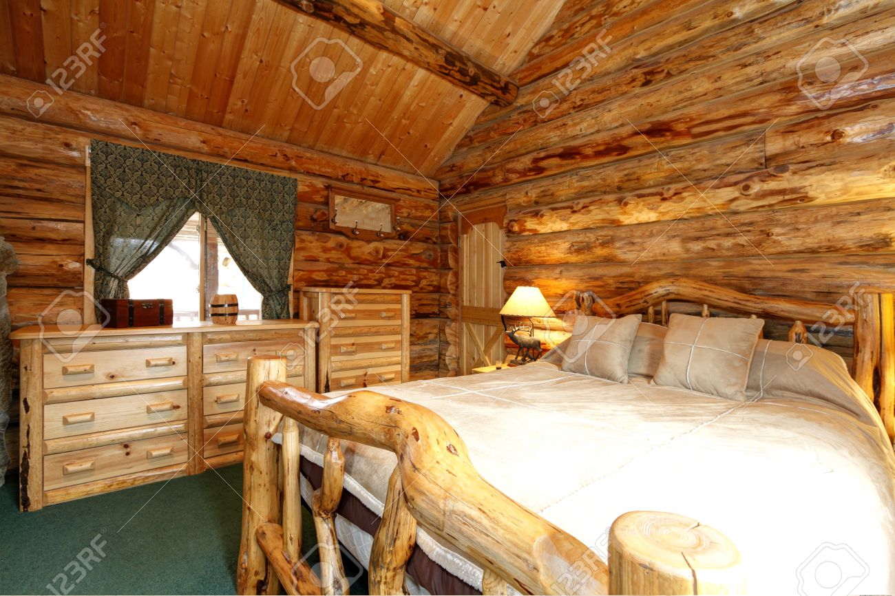 Warme gezellige slaapkamer met rustieke bed, nachtkastje en ...