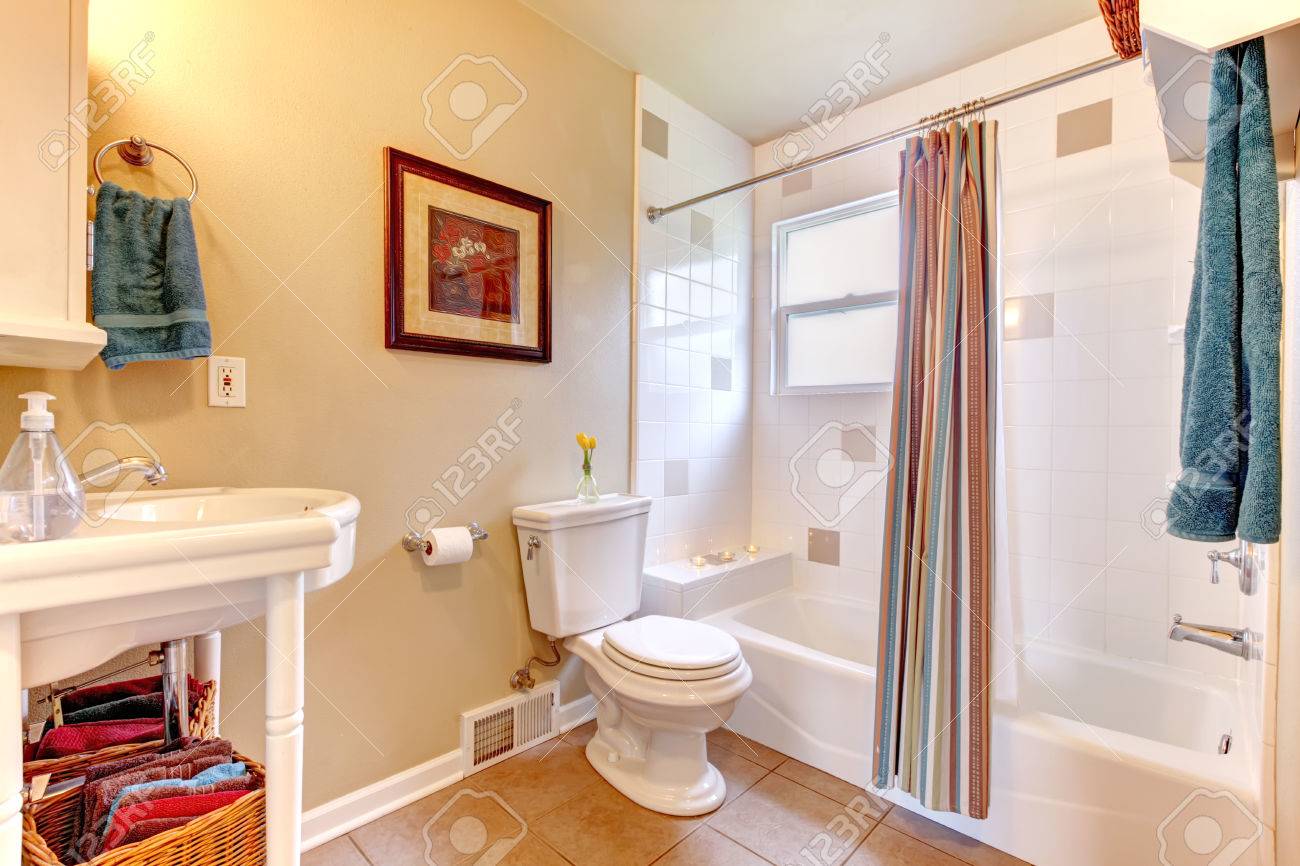 Bianco brillante e avorio bagno con pavimento di piastrelle beige ...