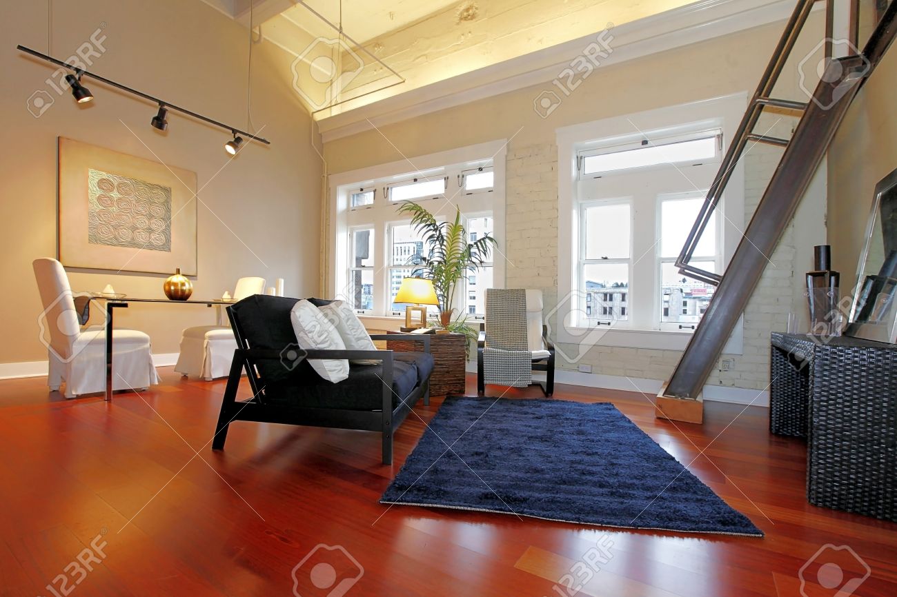 Salon moderne avec mur de briques peint, plafond haut, plancher de ...