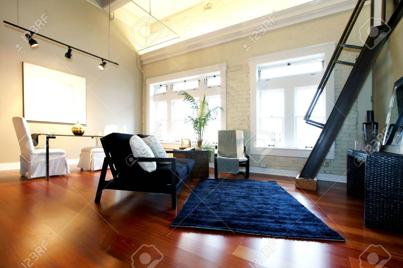 Salon moderne avec mur de briques peint, plafond haut, plancher de ...
