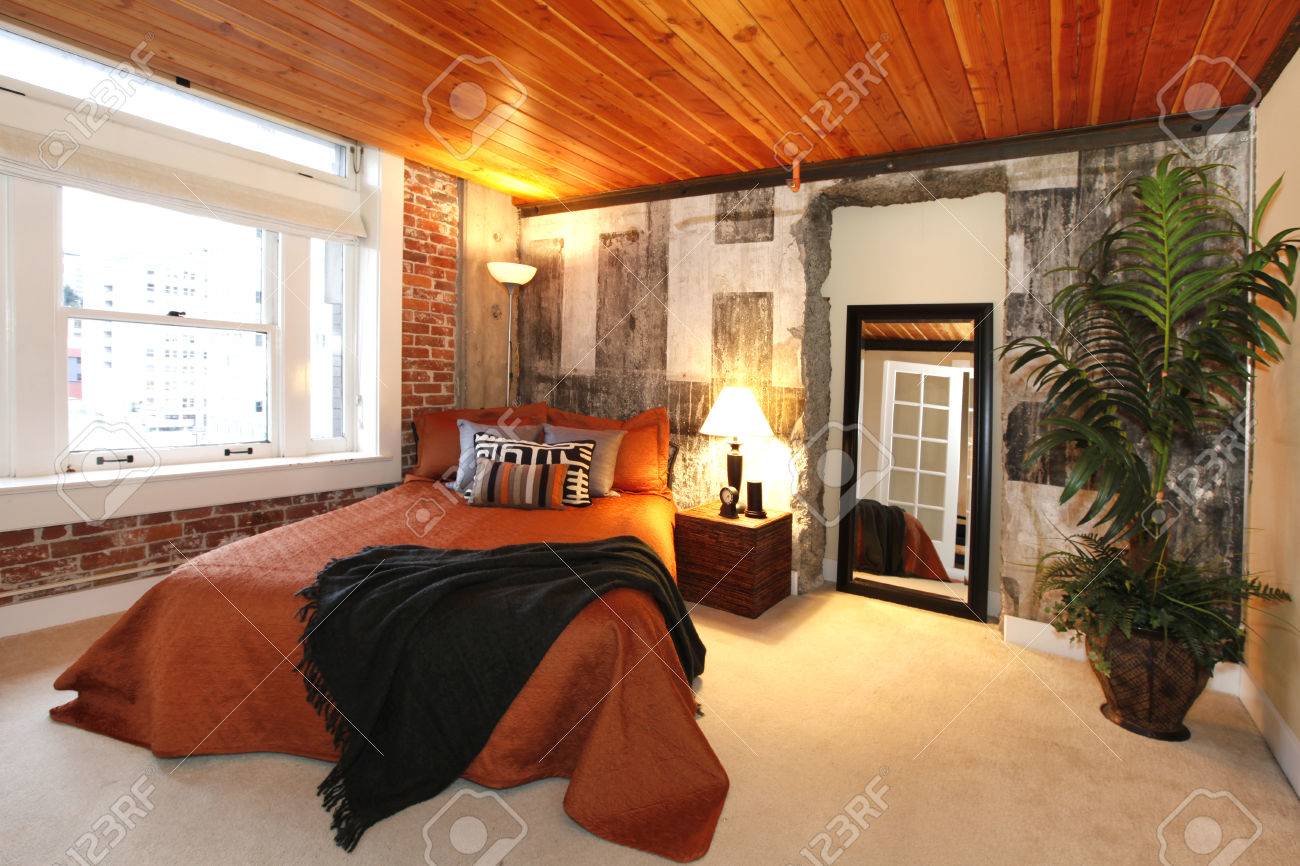 Moderne slaapkamer met bakstenen bekleding, beton gebroken muur en ...